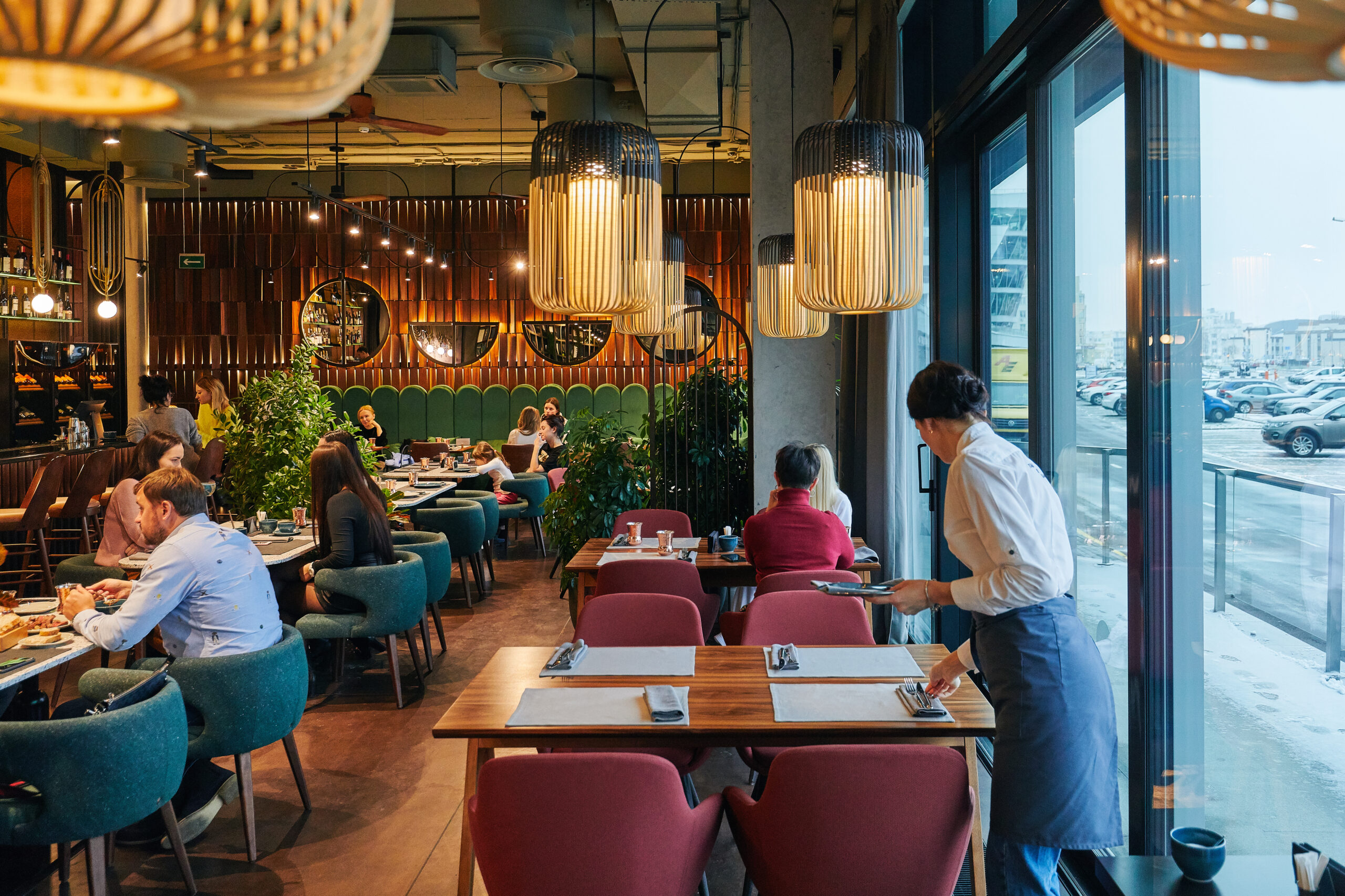 a restaurant with people and waiters, with large windows, the interior in a modern beautiful style