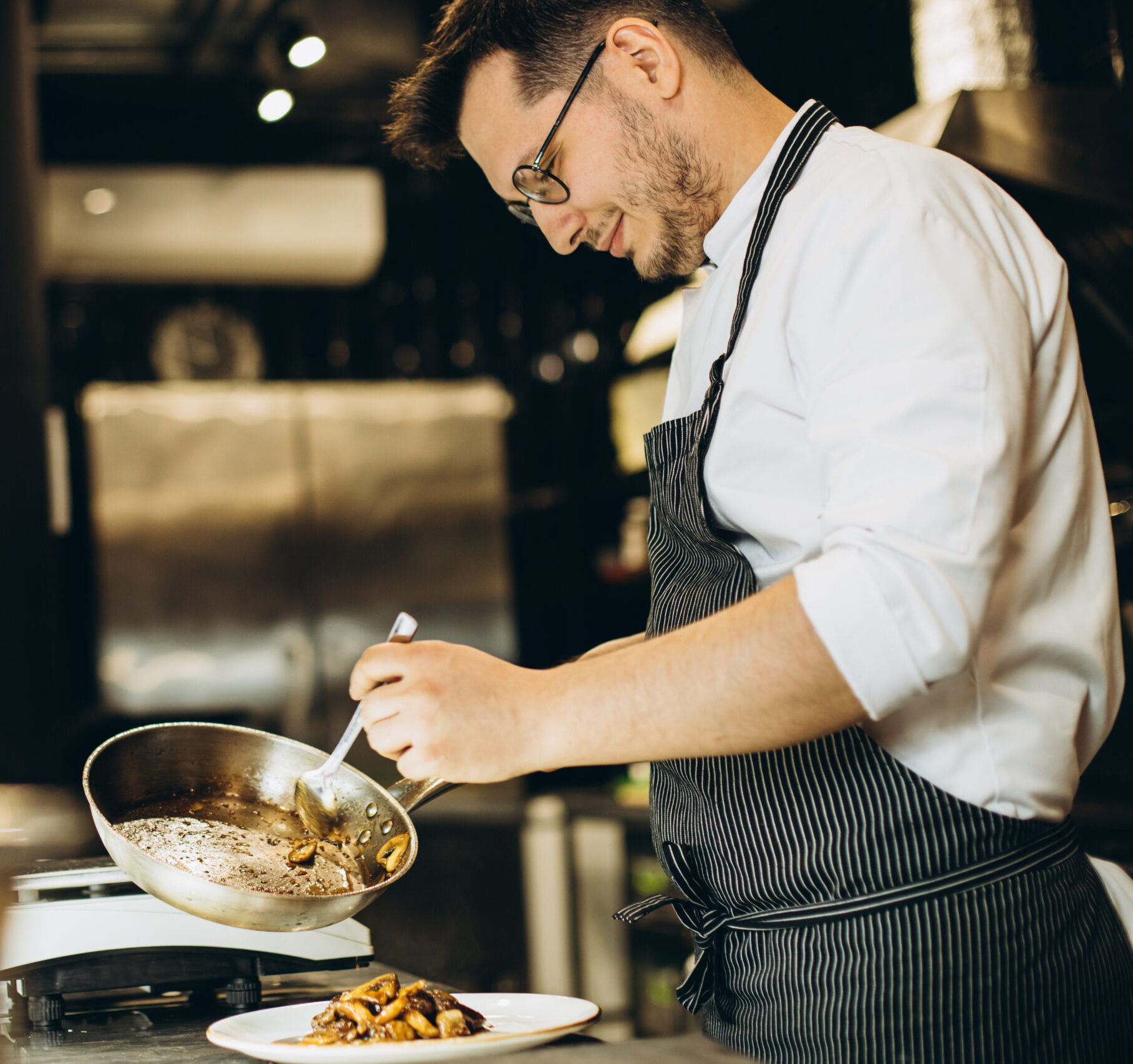 Man chef cooking asian chicken at a cafe kitchen